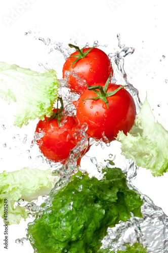 Photo: Three Fresh red Tomatoes and lettuce in splash water Isolated on Three Fresh red Tomatoes and lettuce in splash water Isolated on