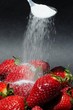 Sprinkling sugar onto strawberries © Arena Photo UK