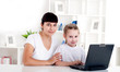 Mom and daughter are working together for a laptop Mom and daughter are working together for a laptop