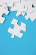White Jigsaw pieces on a blue paper background White Jigsaw pieces on a blue paper background