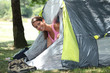 Young woman popping her head out of a tent