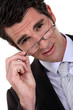 Young businessman removing glasses