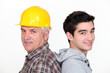 Tradesman standing back to back with his apprentice