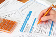 Hand completing a health insurance claim with invoices