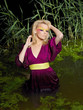 Foto: The young woman in a bright make-up costs on a belt in water The young woman in a bright make-up costs on a belt in water