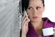 Office worker with mobile telephone and mug of coffee