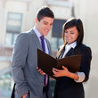 Business couple outdoors with files.