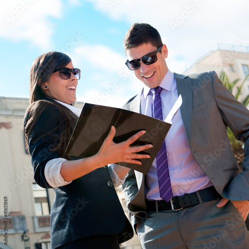 Photo: Business couple outdoors with catalog. Business couple outdoors with catalog.