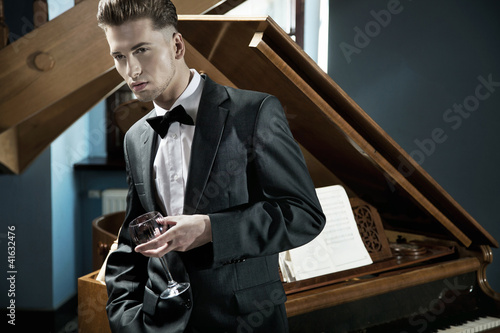 Photo: Young pianist with glass of wine Young pianist with glass of wine
