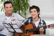 Adolescent boy learning to play the guitar