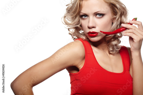 Photo: Young woman with chili pepper isolated on white Young woman with chili pepper isolated on white