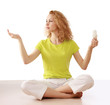 Woman with energy-saving bulb sitting cross-legged on floor.