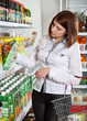 Photo: Woman in a supermarket choosing box of juice Woman in a supermarket choosing box of juice