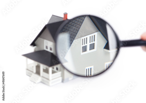 Photo: Hand holding magnifying glass in front of the house Hand holding magnifying glass in front of the house