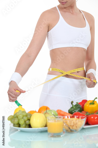 Photo: Woman measuring her waist Woman measuring her waist