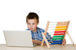 Kind mit Notebook und Abakus am Schreibtisch Kind mit Notebook und Abakus am Schreibtisch