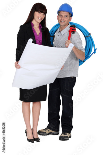 Foto: Plumber stood with female architect Plumber stood with female architect