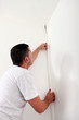 handyman hiding a cable with a plinth