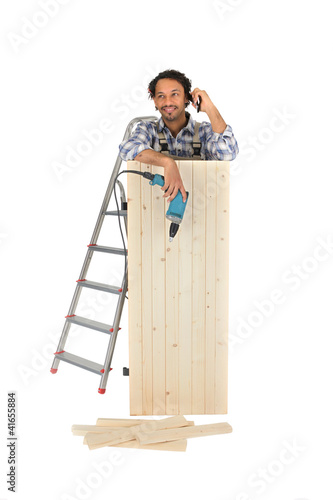 Photo: Worker with a paint stripper talking on the phone Worker with a paint stripper talking on the phone