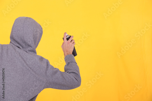 Foto: Man in a hoodie spray painting Man in a hoodie spray painting