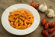 Penne pasta cooked with tomato sauce, garlic and oregano