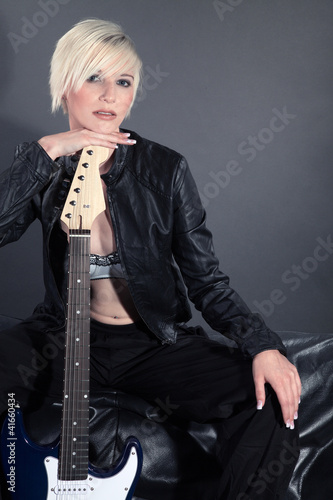Foto: Hübsche blonde Frau mit E Gitarre blickt cool Hübsche blonde Frau mit E Gitarre blickt cool