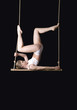 Young woman gymnast on black background