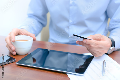 Photo: Man using a credit card for online shopping Man using a credit card for online shopping