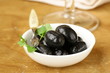 Pickle black olives in a bowl on a wooden table