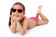 enfant allongée  en maillot de bain et lunette de soleil