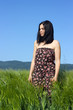 Foto: Young woman standing in the green wheat field Young woman standing in the green wheat field
