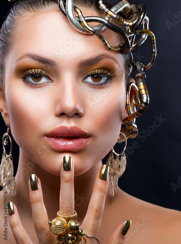 Photo: Golden Makeup and Jewelry. Fashion Model Portrait Golden Makeup and Jewelry. Fashion Model Portrait