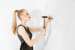 Girl hammers a nail into a wall