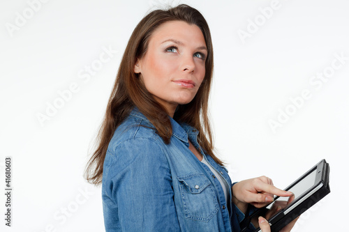 Foto: junge frau mit touchpad schaut nachdenklich nach oben junge frau mit touchpad schaut nachdenklich nach oben
