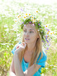 The happy young woman in a wreath from wild flowers The happy young woman in a wreath from wild flowers