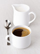 cup of coffee and milk jug, with spoon