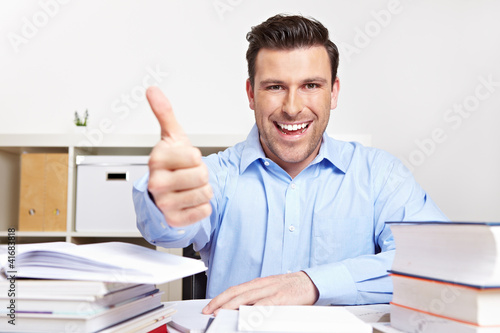 Foto: Mann mit Büchern hält Daumen hoch Mann mit Büchern hält Daumen hoch