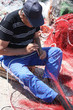 pescatore che ripara la rete