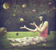 Beautiful young woman on the green meadow with apples