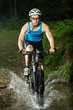Mountainbiker durchquert Bachbett Mountainbiker durchquert Bachbett