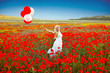 Portrait of romantic woman in poppy field in white dress