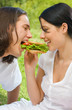 Young couple eating together outdoors Young couple eating together outdoors
