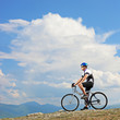 A man posing with a mountain bike on a ridge A man posing with a mountain bike on a ridge