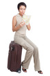 Thinking tourist woman looking at city map on suitcase isolated