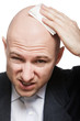 Hand holding tissue wiping or drying bald sweat head