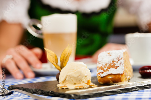 Photo: Junge Frau in Bayerischer Tracht in Restaurant Junge Frau in Bayerischer Tracht in Restaurant