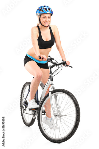 Photo: Portrait of a smiling female biker with helmet sitting on a bike Portrait of a smiling female biker with helmet sitting on a bike
