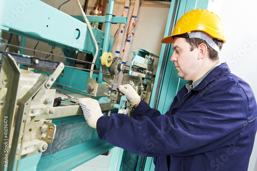 Photo: machinist with spanner adjusting lift mechanism machinist with spanner adjusting lift mechanism