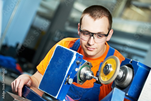Photo: industrial worker at sharpening machine tool industrial worker at sharpening machine tool