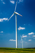 Wind turbines on green field with blue sky background Wind turbines on green field with blue sky background